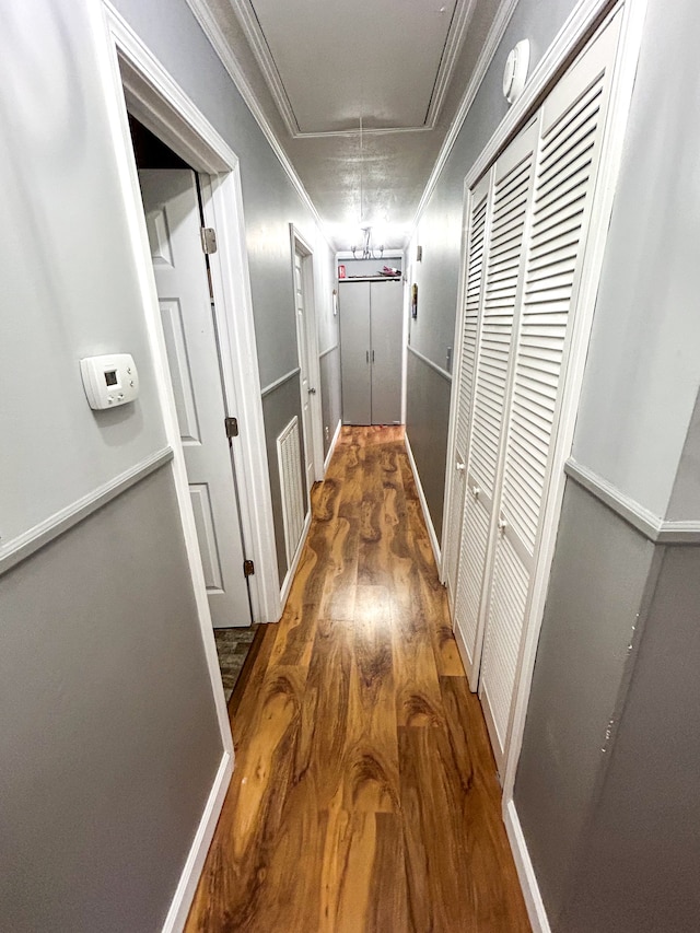 hall with ornamental molding and wood-type flooring