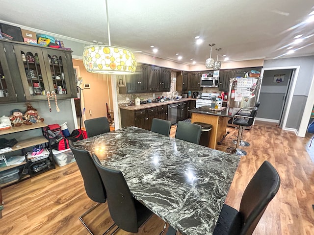 dining area with light wood-type flooring and ornamental molding