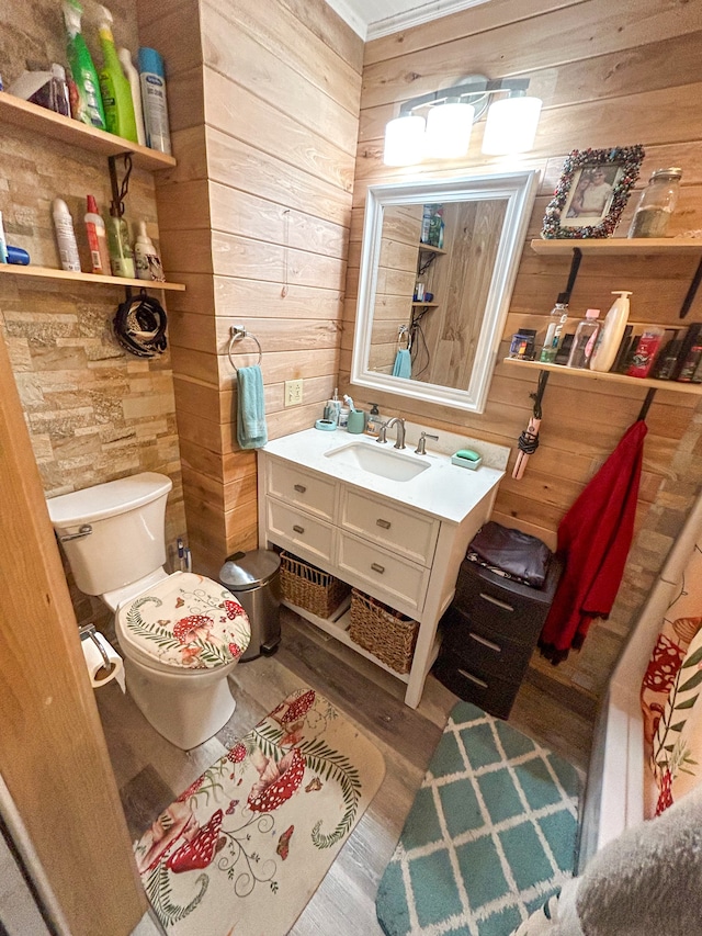 bathroom with vanity, hardwood / wood-style floors, toilet, and wood walls