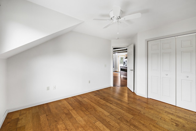 unfurnished bedroom with vaulted ceiling, hardwood / wood-style floors, ceiling fan, and a closet