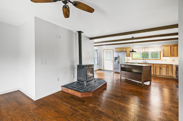 kitchen featuring hanging light fixtures, a wood stove, stainless steel appliances, dark hardwood / wood-style floors, and ceiling fan