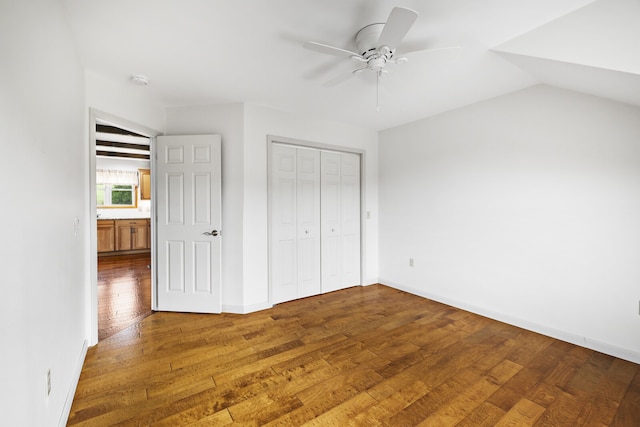 unfurnished bedroom featuring lofted ceiling, a closet, ceiling fan, and hardwood / wood-style floors