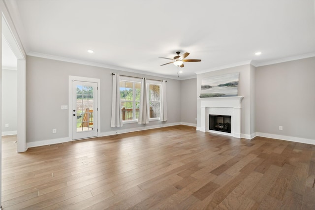 unfurnished living room featuring a fireplace, crown molding, a ceiling fan, and wood finished floors