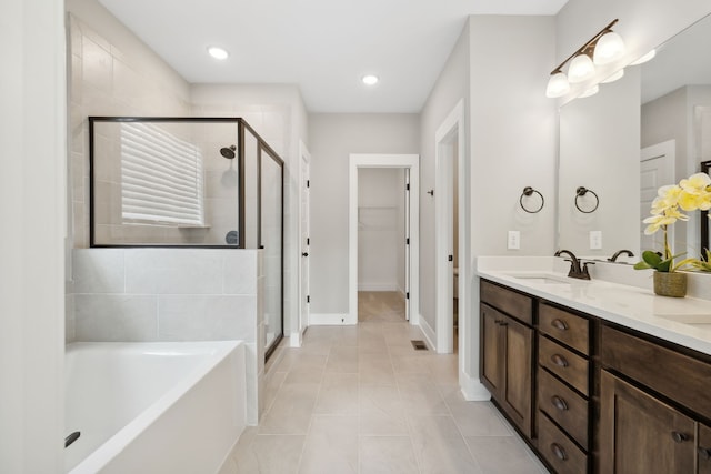 bathroom featuring vanity, independent shower and bath, and tile patterned floors