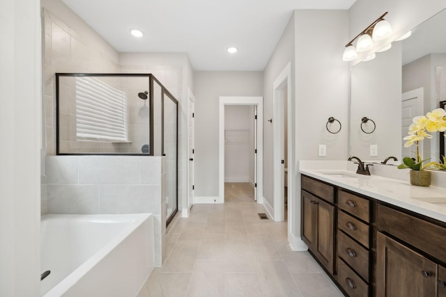 full bathroom with a shower stall, a spacious closet, a bath, and a sink