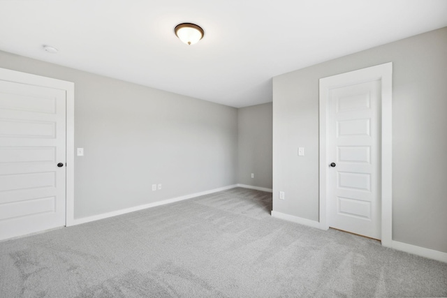 empty room featuring baseboards and carpet floors