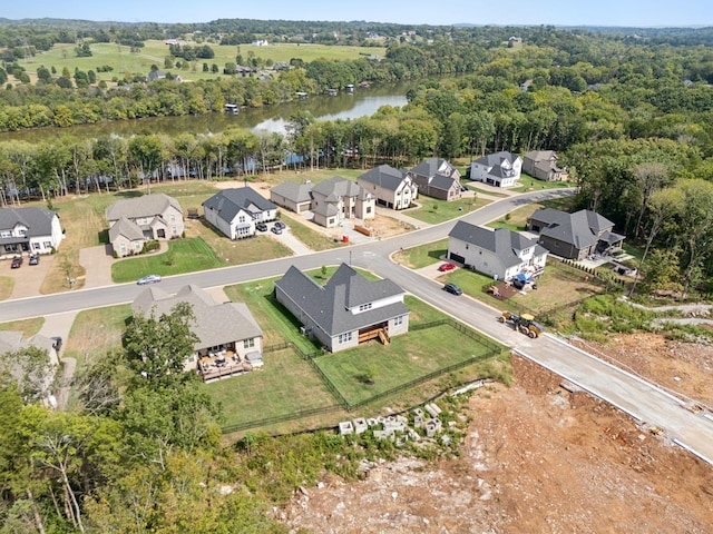 birds eye view of property with a residential view, a view of trees, and a water view