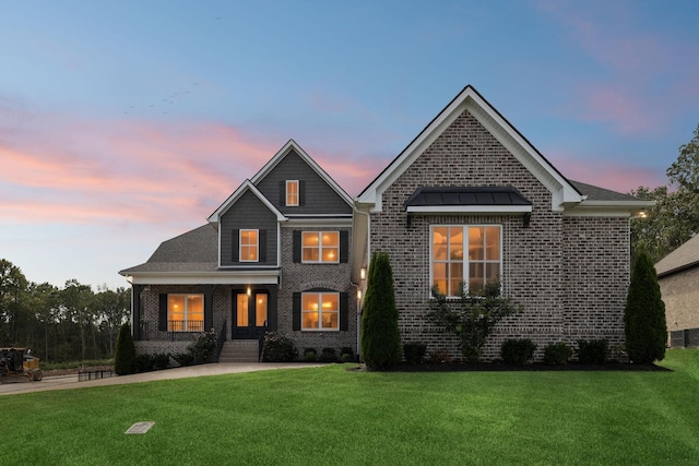 view of front of property with brick siding and a yard