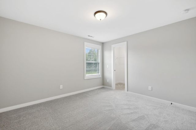 empty room with light carpet, visible vents, and baseboards