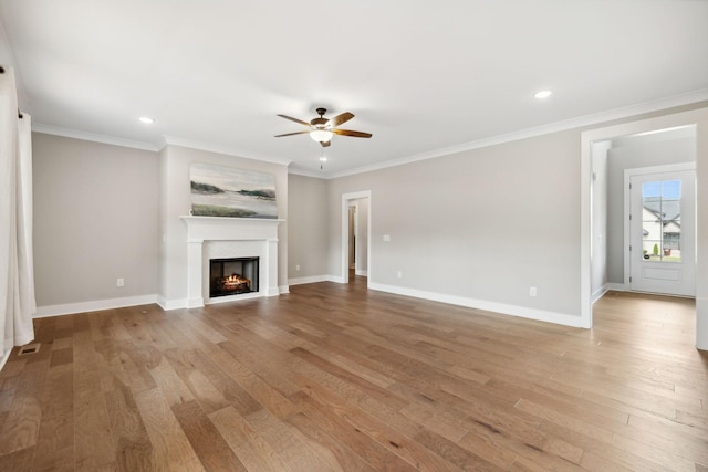 unfurnished living room with light wood-style flooring, baseboards, and ornamental molding