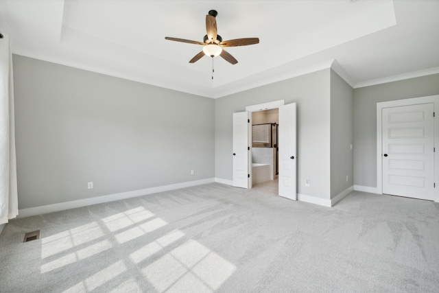 unfurnished bedroom featuring ceiling fan, crown molding, light carpet, and ensuite bath