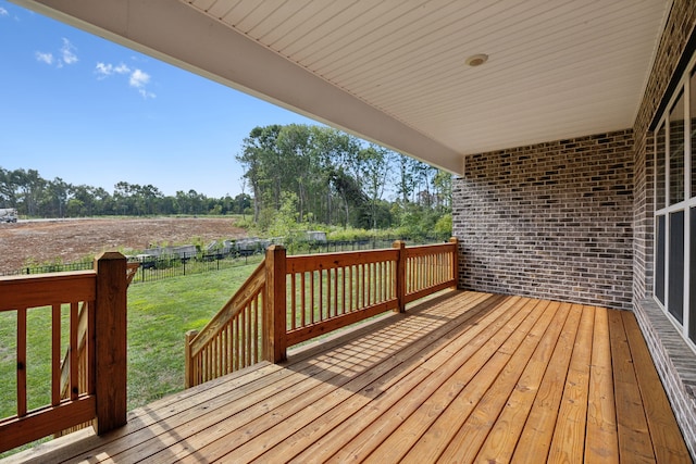 wooden deck with a yard and a rural view