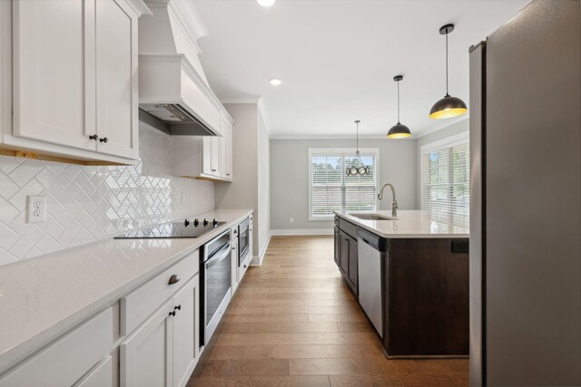 kitchen featuring light hardwood / wood-style floors, stainless steel appliances, sink, decorative backsplash, and white cabinetry