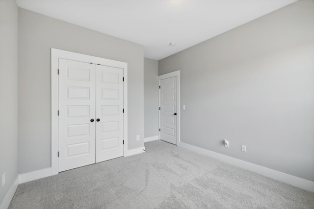 unfurnished bedroom featuring a closet, baseboards, and carpet floors