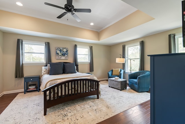 bedroom with ceiling fan, wood-type flooring, and multiple windows