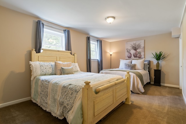 bedroom with dark carpet and multiple windows