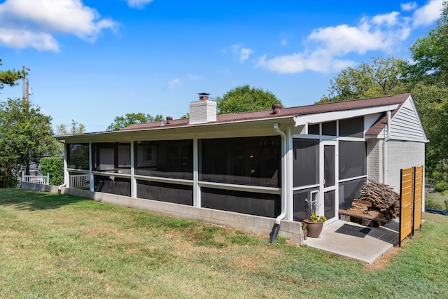 back of property with a yard and a sunroom