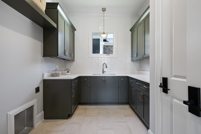 interior space featuring green cabinets, light tile patterned floors, decorative light fixtures, sink, and tasteful backsplash