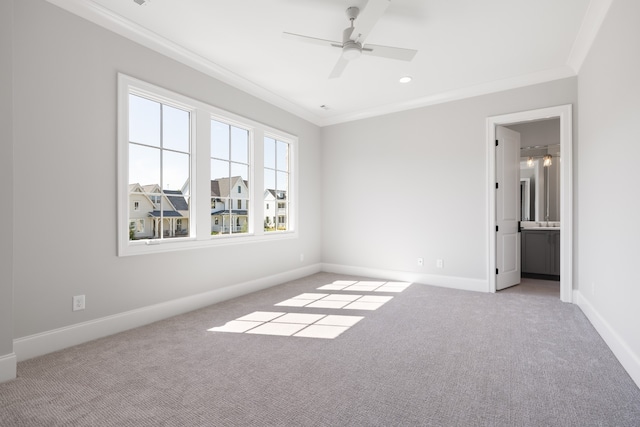 empty room featuring ceiling fan, light colored carpet, and crown molding