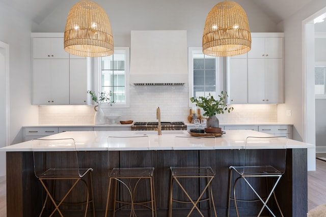 kitchen featuring lofted ceiling, a kitchen breakfast bar, and an island with sink