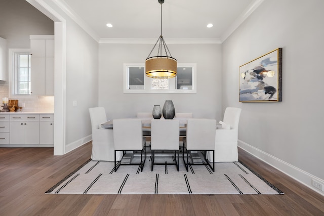 dining space featuring hardwood / wood-style floors and ornamental molding