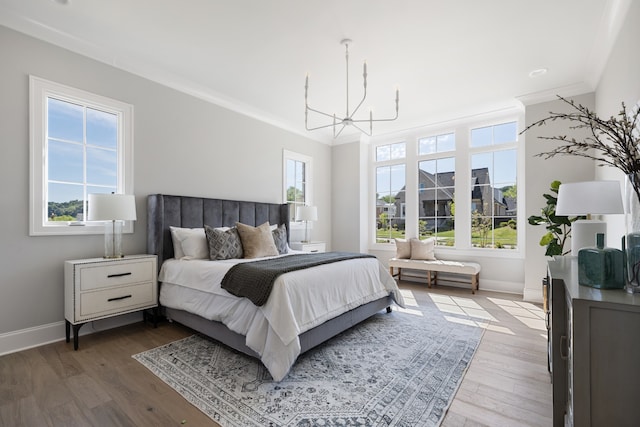 bedroom featuring crown molding, wood-type flooring, and multiple windows