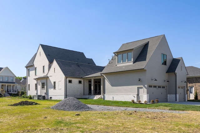 rear view of house with a garage and a yard