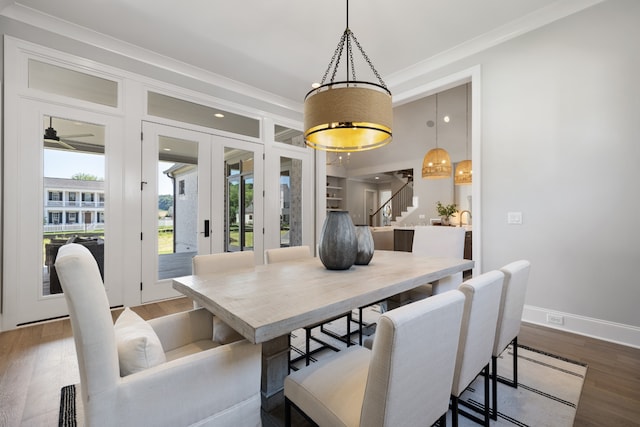 dining space with ornamental molding and hardwood / wood-style flooring