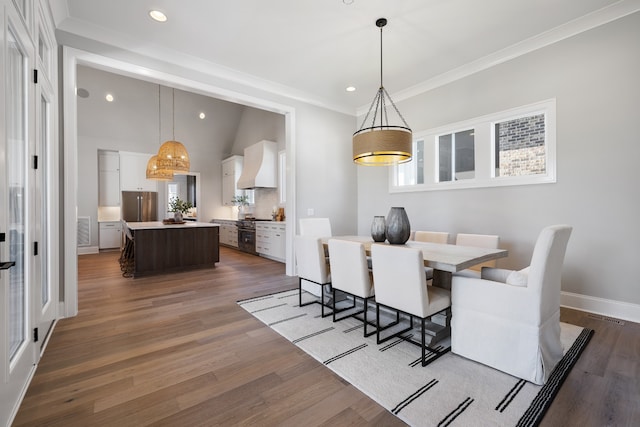 dining space with crown molding, vaulted ceiling, dark hardwood / wood-style flooring, and plenty of natural light