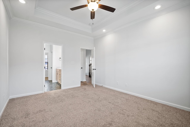 unfurnished bedroom with crown molding, a raised ceiling, ceiling fan, and carpet