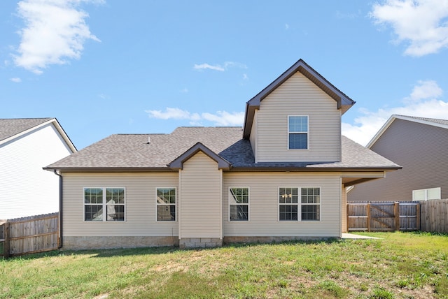 rear view of property featuring a lawn