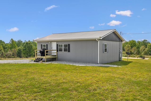 rear view of house with a wooden deck and a yard