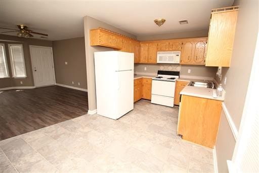 kitchen with white appliances, light hardwood / wood-style flooring, sink, and ceiling fan