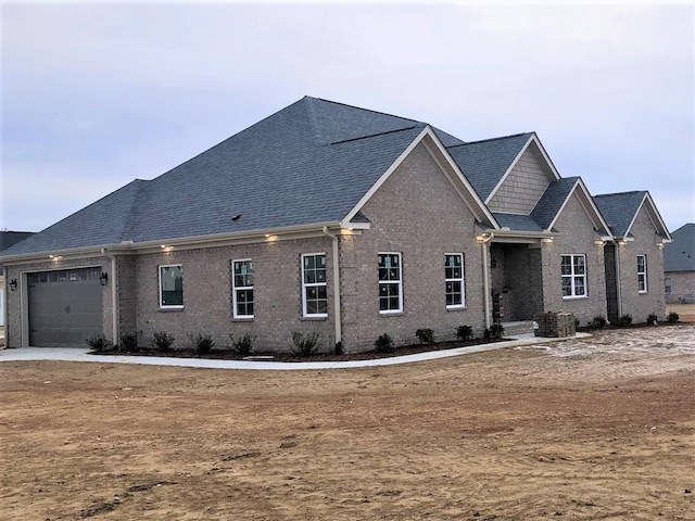 view of front facade with a garage and central AC unit