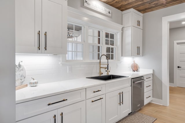 kitchen featuring decorative backsplash, light hardwood / wood-style floors, white cabinetry, and sink