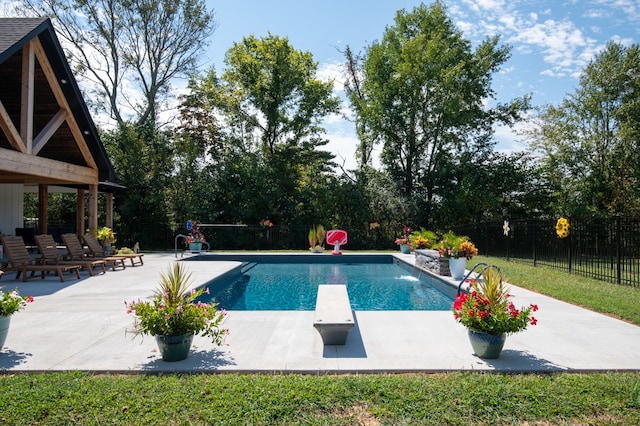 view of swimming pool with a diving board and a patio area