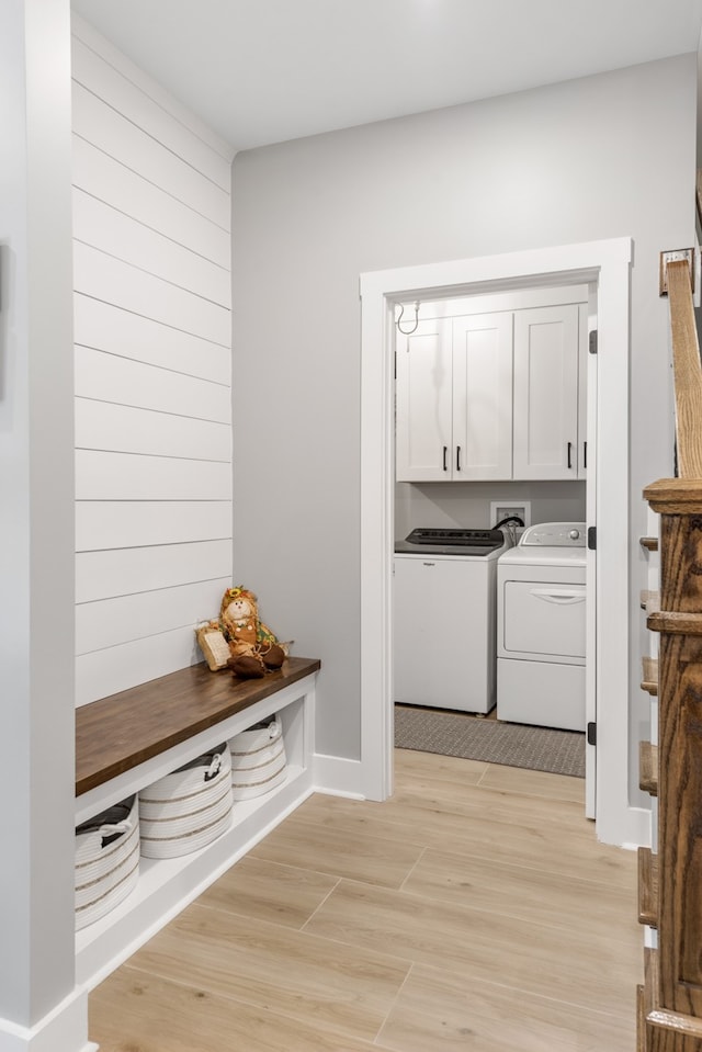 mudroom featuring light wood-type flooring and washer and dryer