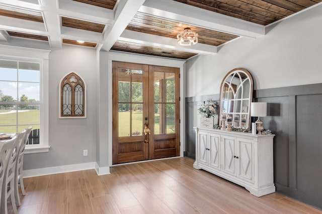 entrance foyer with beam ceiling, light wood-type flooring, and french doors