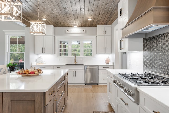 kitchen featuring stainless steel gas stovetop, light hardwood / wood-style floors, a center island, sink, and custom exhaust hood