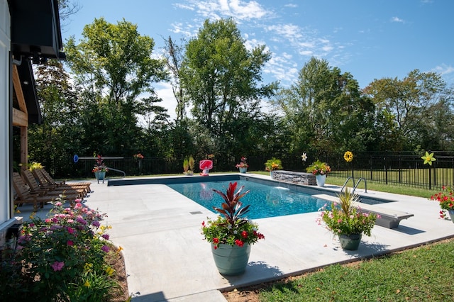 view of swimming pool featuring a diving board and a patio