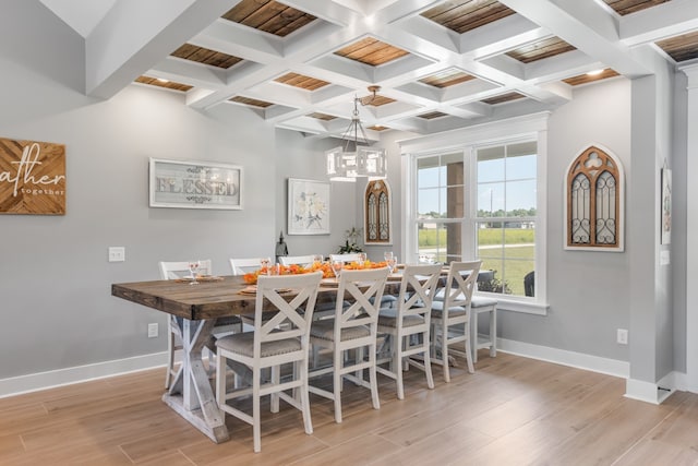 dining space with coffered ceiling, light hardwood / wood-style floors, a notable chandelier, and beam ceiling