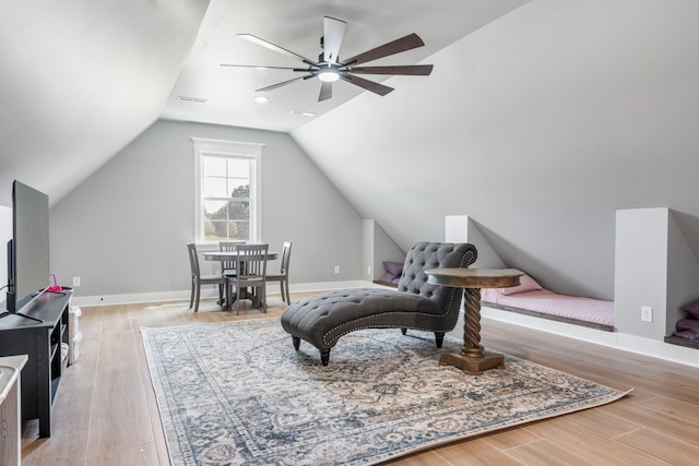 living area featuring lofted ceiling, light hardwood / wood-style flooring, and ceiling fan