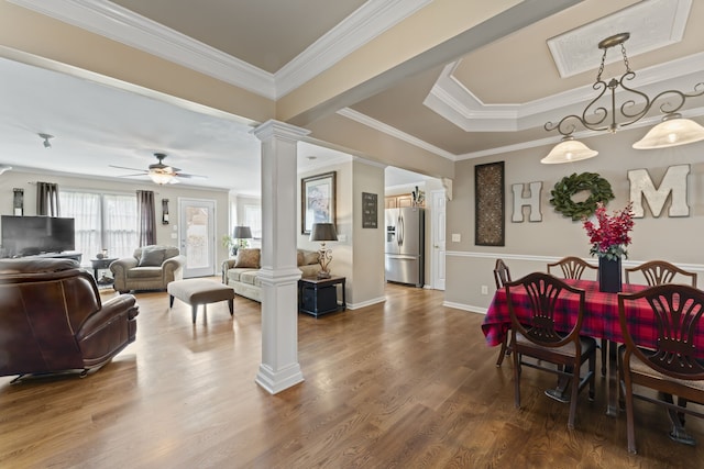 dining space with crown molding, ceiling fan, hardwood / wood-style flooring, and ornate columns