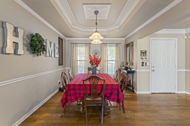 dining space with ornamental molding, a raised ceiling, and dark hardwood / wood-style floors