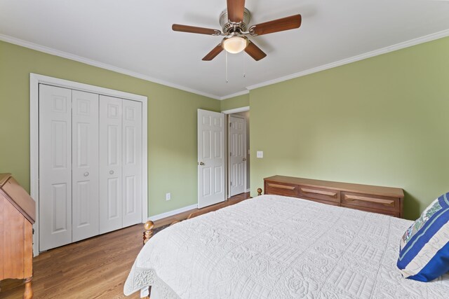 bedroom with a closet, ceiling fan, wood-type flooring, and ornamental molding