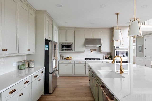 kitchen featuring pendant lighting, tasteful backsplash, sink, stainless steel appliances, and light stone countertops