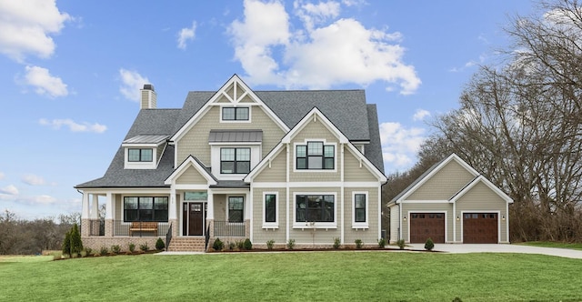 craftsman-style house with a garage, an outbuilding, a front yard, and covered porch