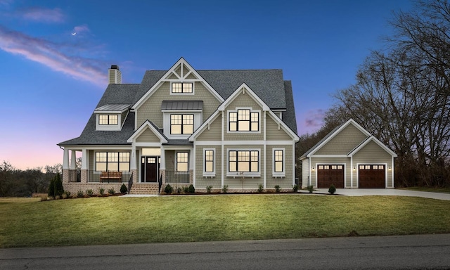 view of front of house featuring a porch, a garage, an outdoor structure, and a lawn