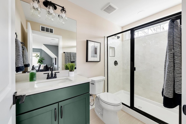 bathroom with vanity, a shower with shower door, and toilet