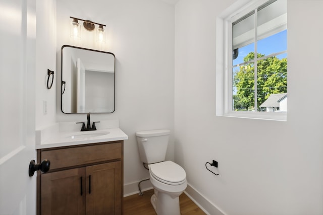 bathroom featuring wood-type flooring, toilet, and vanity